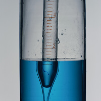 A blood sample tube of clear and blue fluid in the light