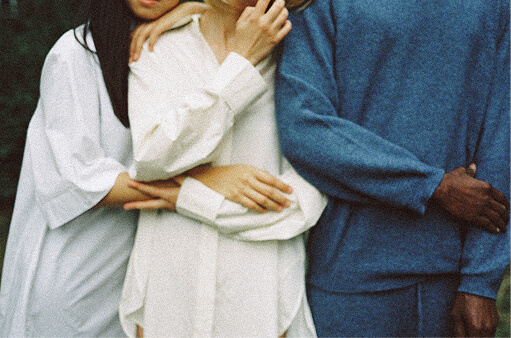 Two people standing close together, one arm wrapped around the other