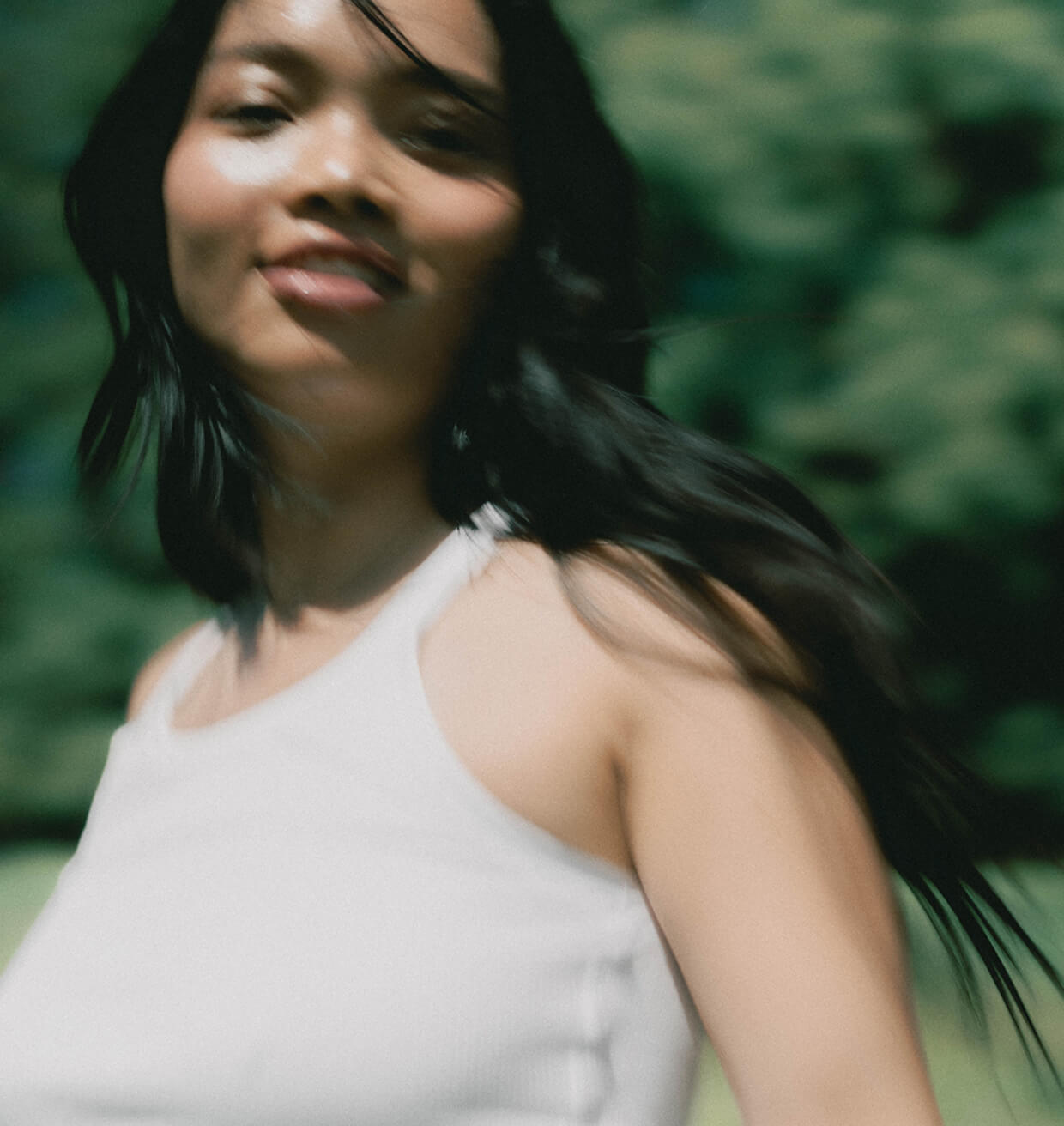A woman turning towards the camera in bright daylight